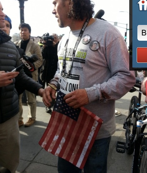 La bandiera insanguinata in mano a un attivista americano