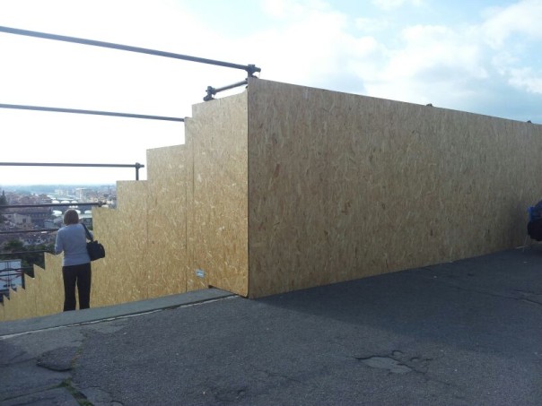 L'alta parete di compensato che circonda la scalinata e che nega di fatto la visuale del paesaggio