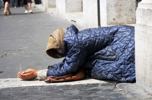 Una donna chiede l'elemosina