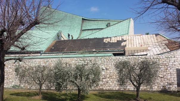 Operai al lavoro sul tetto della chiesa di San Giovanni Battista, sull'autostrada A1, progettata dall'architetto Michelucci. Le raffiche di vennto hanno fatto volar via la pregiata copertura in rame verde