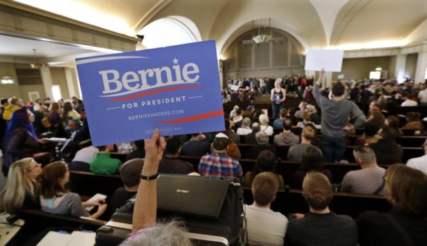 A Bernie Sanders supporter holds up a sign during a Democratic caucus Saturday, March 26, 2016, at Seattle's Town Hall. Democrats caucused statewide in support of either Hillary Clinton or Sanders. (ANSA/AP Photo/Elaine Thompson) [CopyrightNotice: Copyright 2016 The Associated Press. All rights reserved. This material may not be published, broadcast, rewritten or redistributed without permission.]