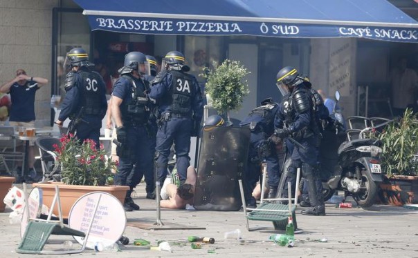 French police officers apprehend soccer supporters during clashes in downtown Marseille, France, Saturday, June 11, 2016. Riot police have thrown tear gas canisters at soccer fans Saturday in Marseille's Old Port in a third straight day of violence in the city. (ANSA/AP Photo/Darko Bandic)
