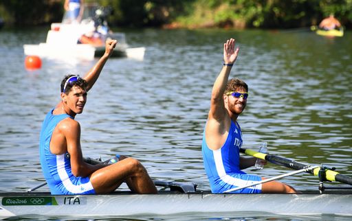 Italy's Marco di Costanzo and Italy's Giovanni Abagnale (L) wave after winning the Men's Pair Semifinal rowing competition at the Lagoa stadium during the Rio 2016 Olympic Games in Rio de Janeiro on August 9, 2016. / AFP PHOTO / Damien MEYER
