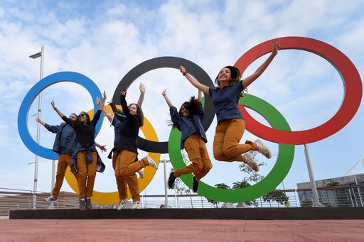 TOPSHOT - People jump for a picture in front of Olympic Rings set at the Olympic parc in Rio de Janeiro on August 3, 2016, ahead of the Rio 2016 Olympic Games. / AFP PHOTO / FABRICE COFFRINI