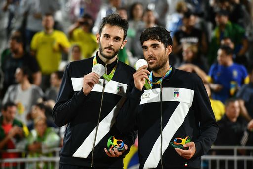 Italy's silver medallists Paolo Nicolai and Daniele Lupo celebrate on the podium at the end of the men's beach volleyball event at the Beach Volley Arena in Rio de Janeiro on August 19, 2016, during the Rio 2016 Olympic Games. / AFP PHOTO / Leon NEAL