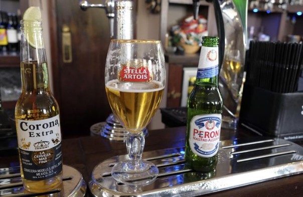 Drinks sit on the bar in a pub in London, Tuesday, Oct. 13, 2015. The world's top two beer makers agreed Tuesday to join forces to create a company that would control nearly a third of the global market. AB InBev's brands include Budweiser, Stella Artois and Corona, while SABMiller produces Peroni and Grolsch. (ANSA/AP Photo/Kirsty Wigglesworth)