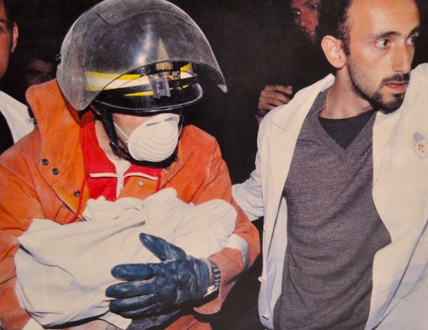 Un vigile del fuoco porta via il corpicino di Caterina (foto Riccardo Germogli/Massimo Sestini)